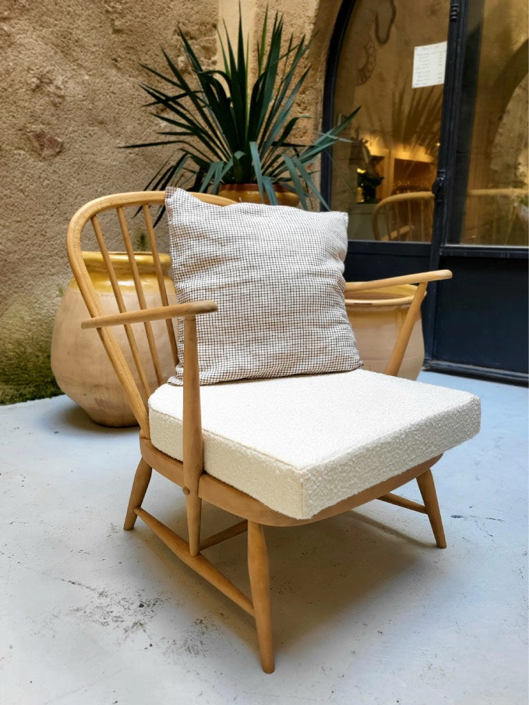 mobilier vintage haut de gamme : fauteuil Ercol en bois clair et tissu bouclette