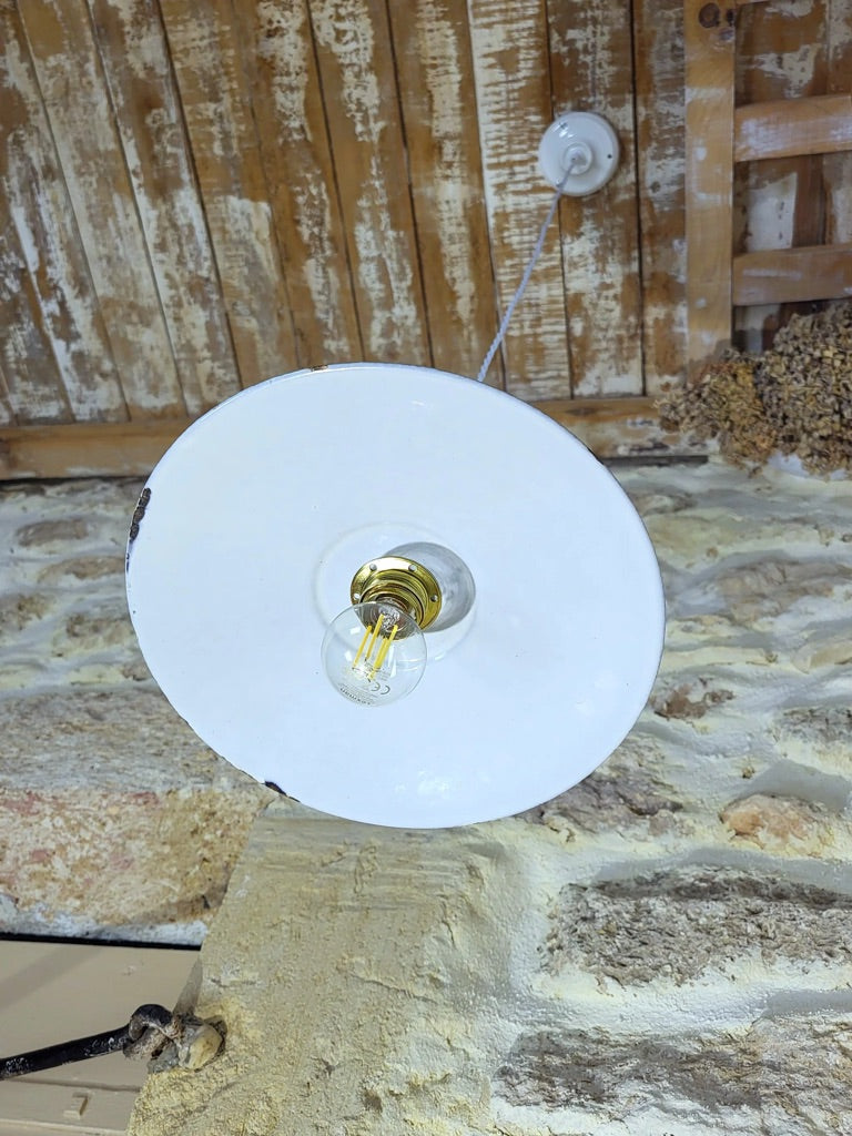 Vue de dessous d’une suspension vintage en métal émaillé vert, luminaire style atelier avec lumière dirigée vers le bas.