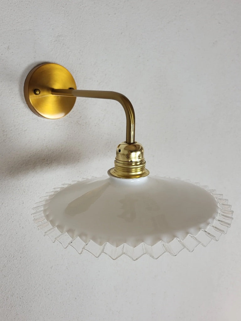 Applique murale en verre opaline blanche sur fond neutre, luminaire rétro années 50 au style épuré et artisanal.