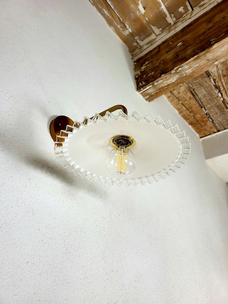 Vue de dessous d’un luminaire mural en verre opaline ondulé, applique murale vintage des années 50 faite main.