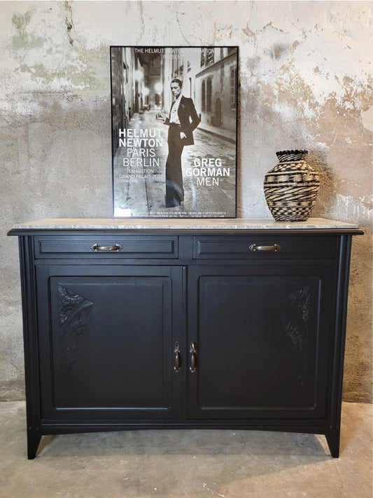 Buffet ancien en bois massif peint en noir mat, avec plateau en marbre gris et détails sculptés, photographié de face.
