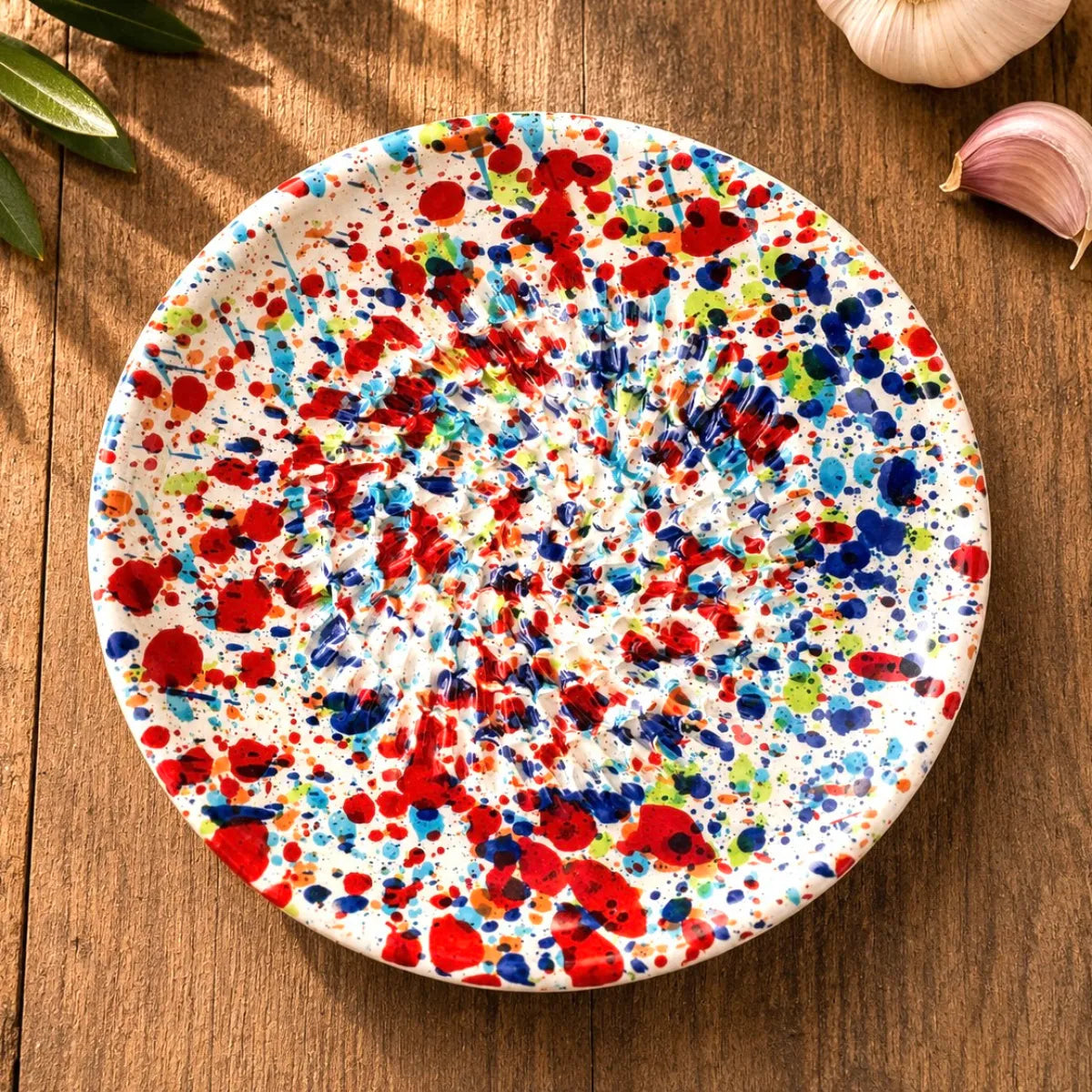 Gratte à ail taches multicolores en céramique pour cuisine sur table en bois 