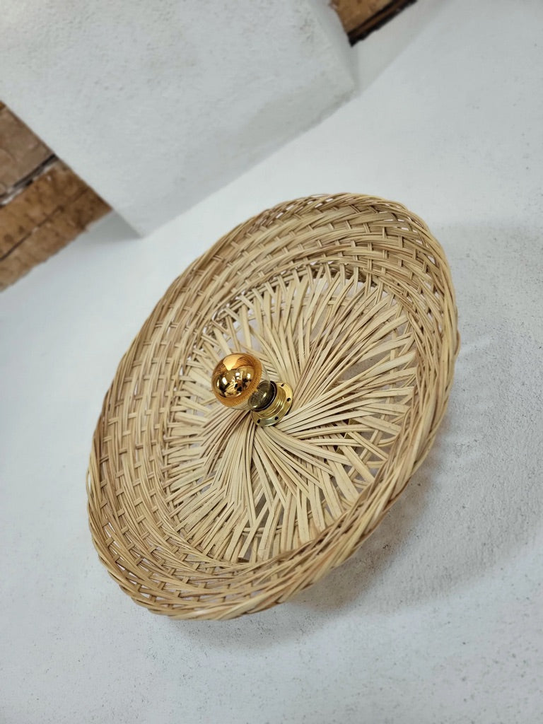 Vue du dessous grande applique murale en fibres végétales, jeu de lumière à travers le tressage naturel.