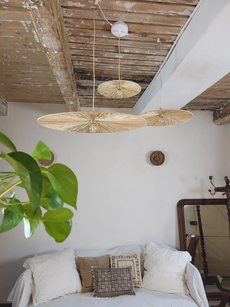 Lustre en fibres naturelles suspendu dans une pièce à vivre au style bohème et méditerranéen, modèle Ombrelle.