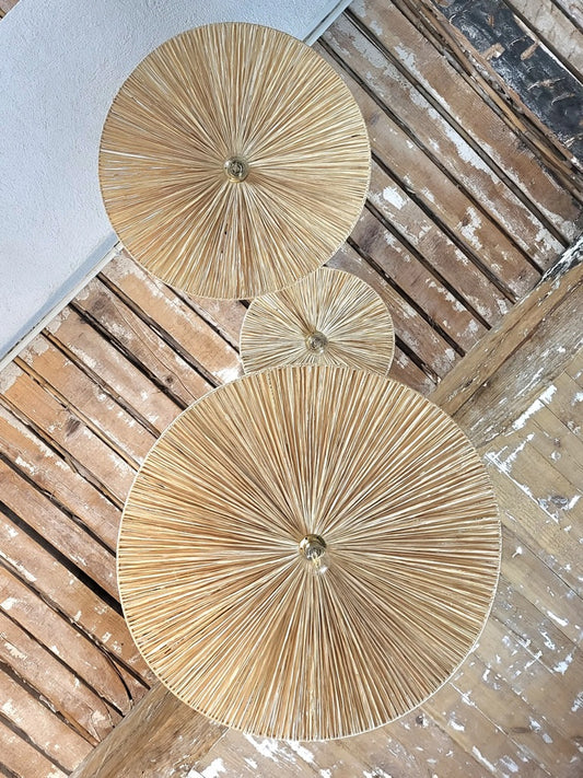 Vue du dessous de la suspension Ombrelle en raphia tressé à la main, lumière douce et ambiance naturelle.