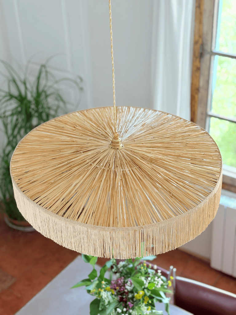 Vue du dessus du grand abat-jour parasol en raphia naturel tissé à la main en France et franges charleston, luminaire artisanal.