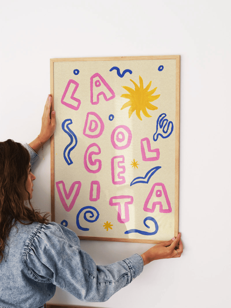 Affiche La Dolce Vita encadrée dans un salon lumineux au style méditerranéen et coloré
