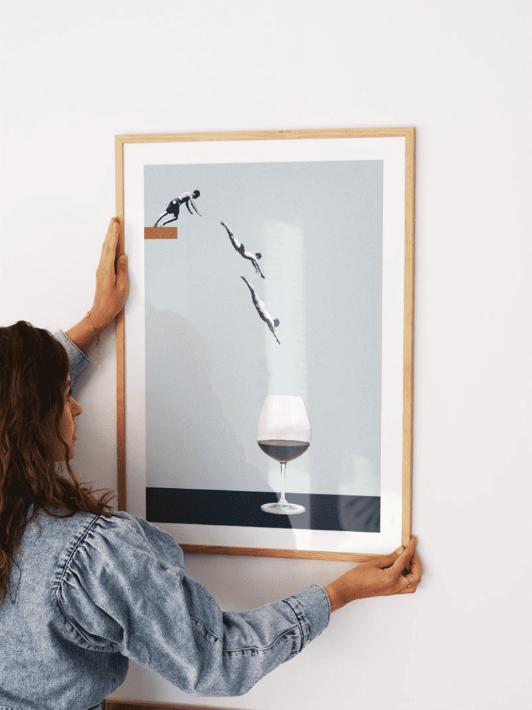 Affiche Les Plongeurs dans le Verre de Vin encadrée dans un salon avec coin bar convivial