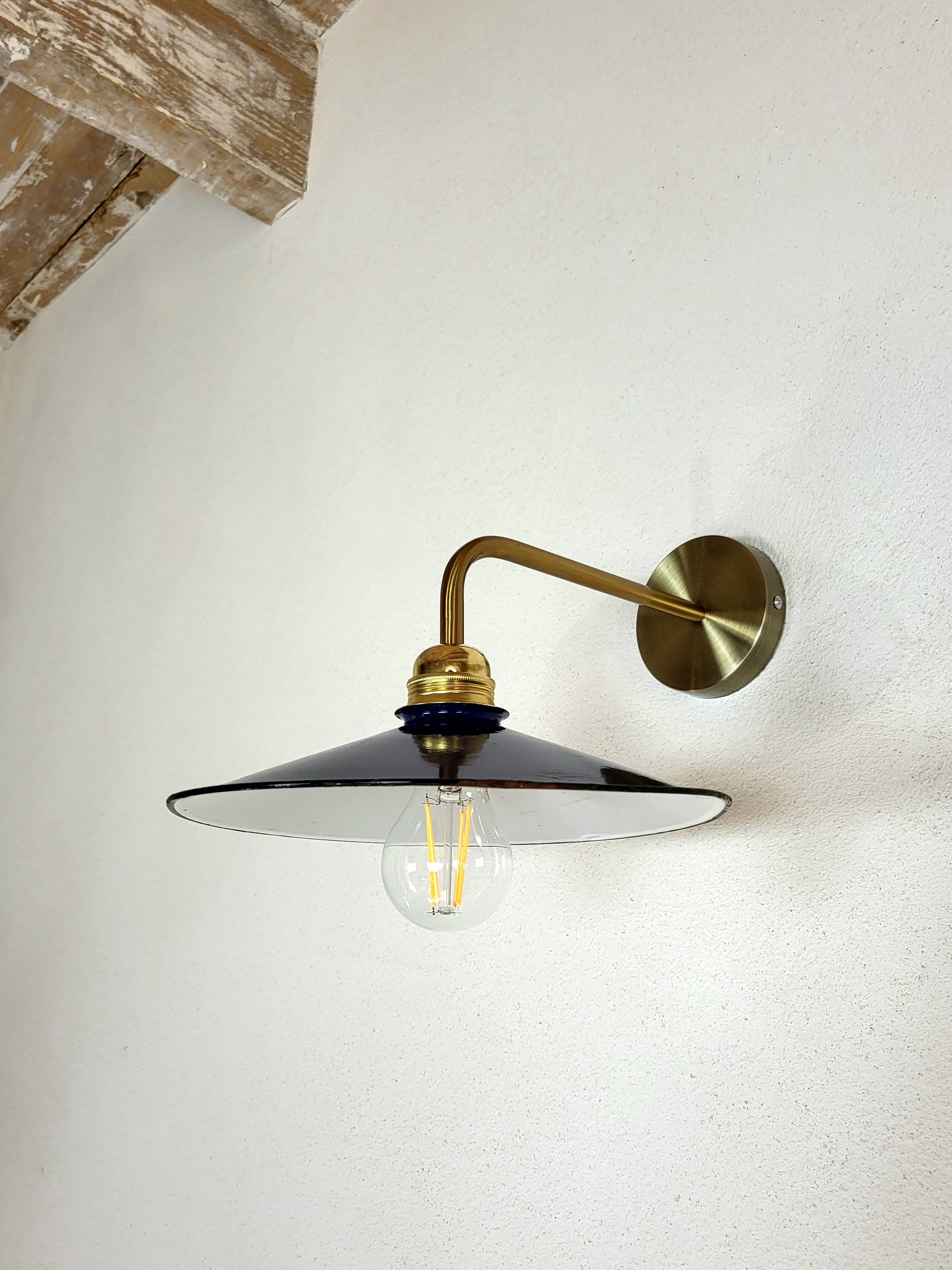 applique bleue murale avec goulot doré sur mur blanc, vu ampoule