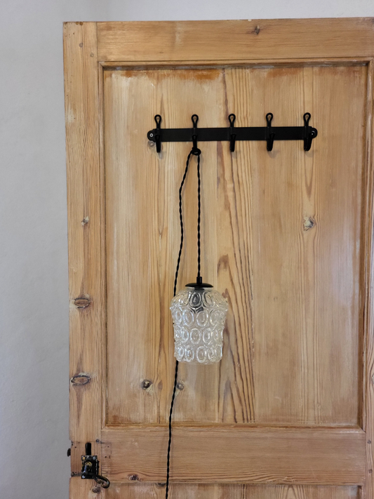 baladeuse suspendue sur une porte en bois avec un fil noir