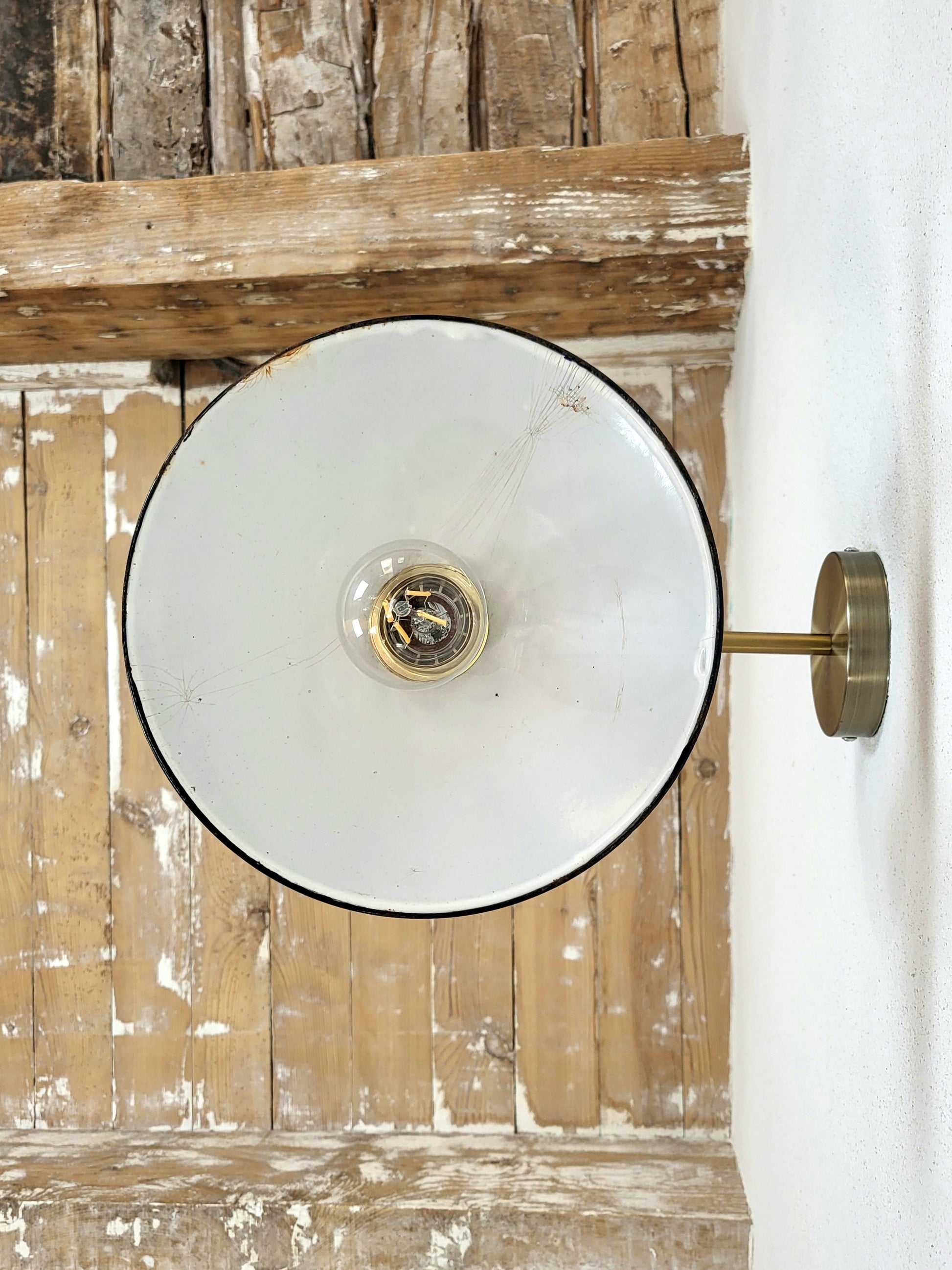 Vue en contre-plongée de l’applique murale en tôle bleue, design atelier avec abat-jour conique, avec un fond en bois brut