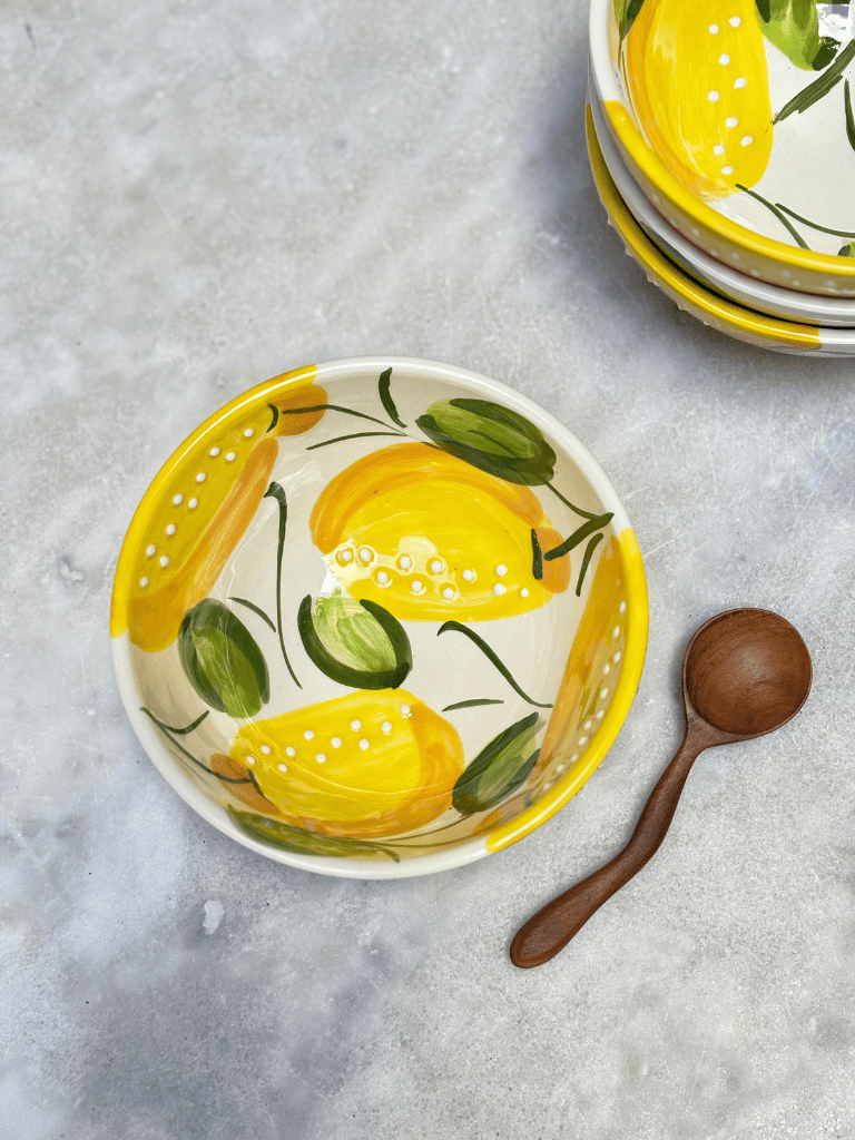 Bol rond artisanal en céramique avec motifs de citrons jaunes, vu du dessus
