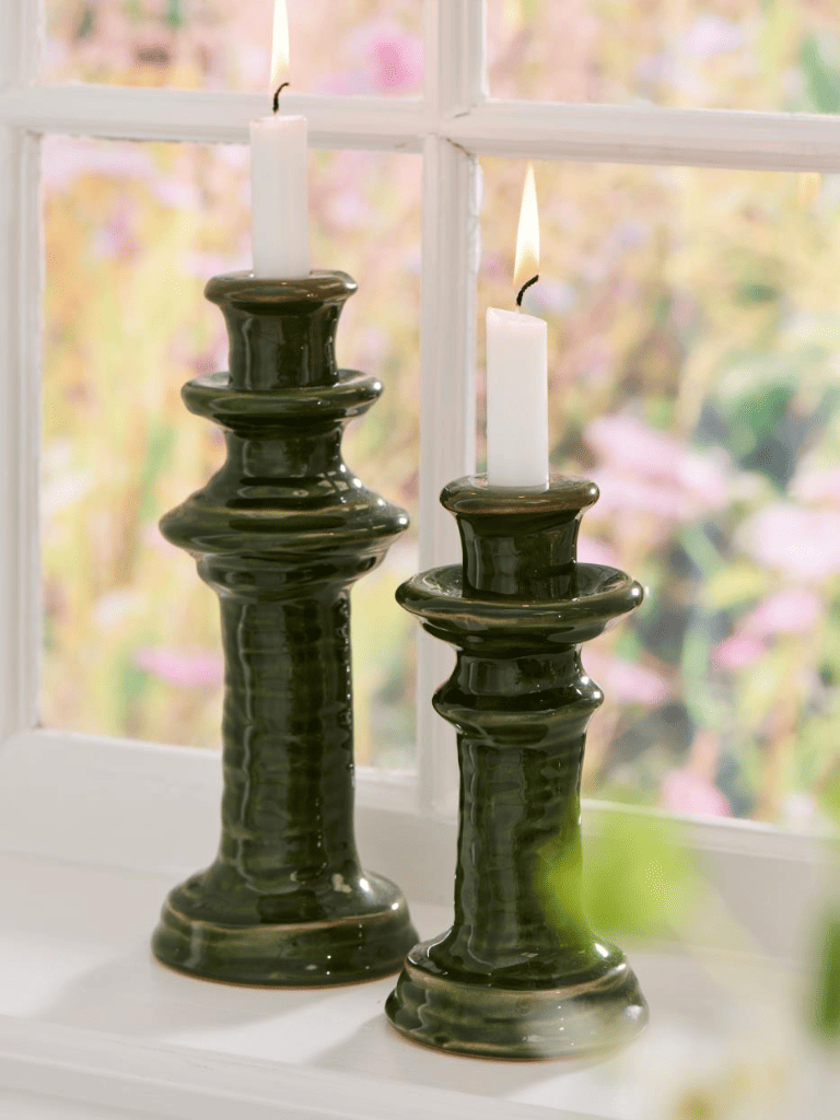 Bougeoirs en céramique verte sur une table dans une ambiance chaleureuse