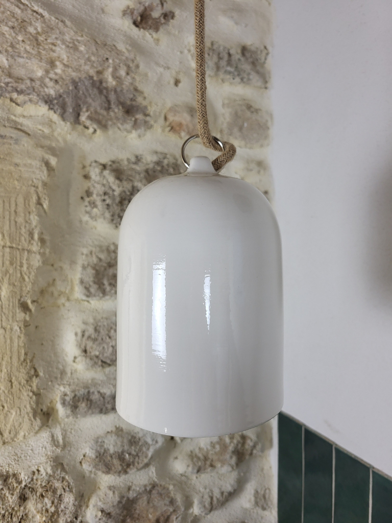 Suspension en céramique blanche émaillée au design épuré et intemporel, dans une cuisine au style naturel