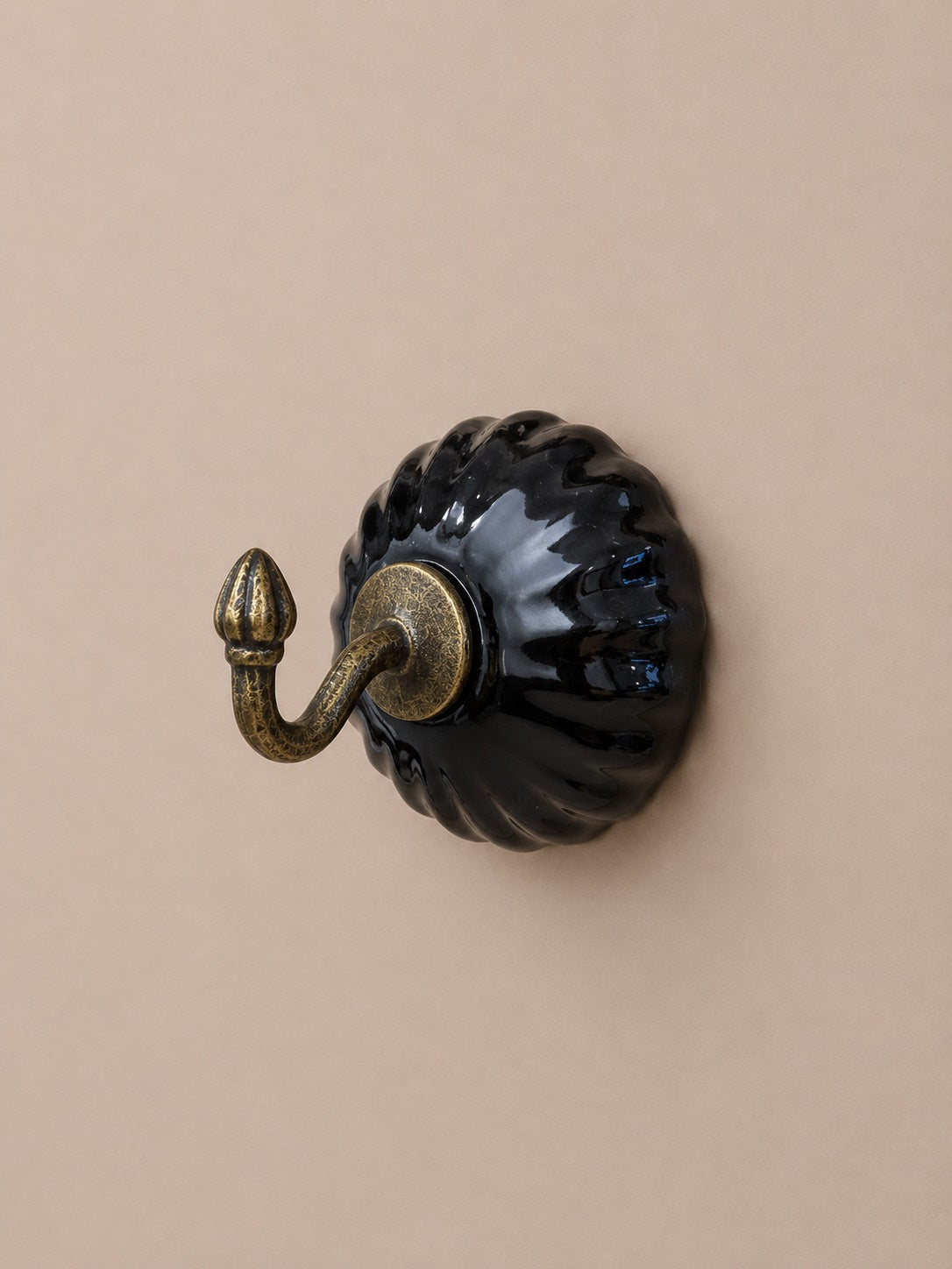 Patère à crochet simple en céramique noir et métal. Fixation murale. Il peut servir de porte torchon dans une cuisine, de porte manteaux ou de porte clés. Avec son style vintage, sublimez votre intérieur.