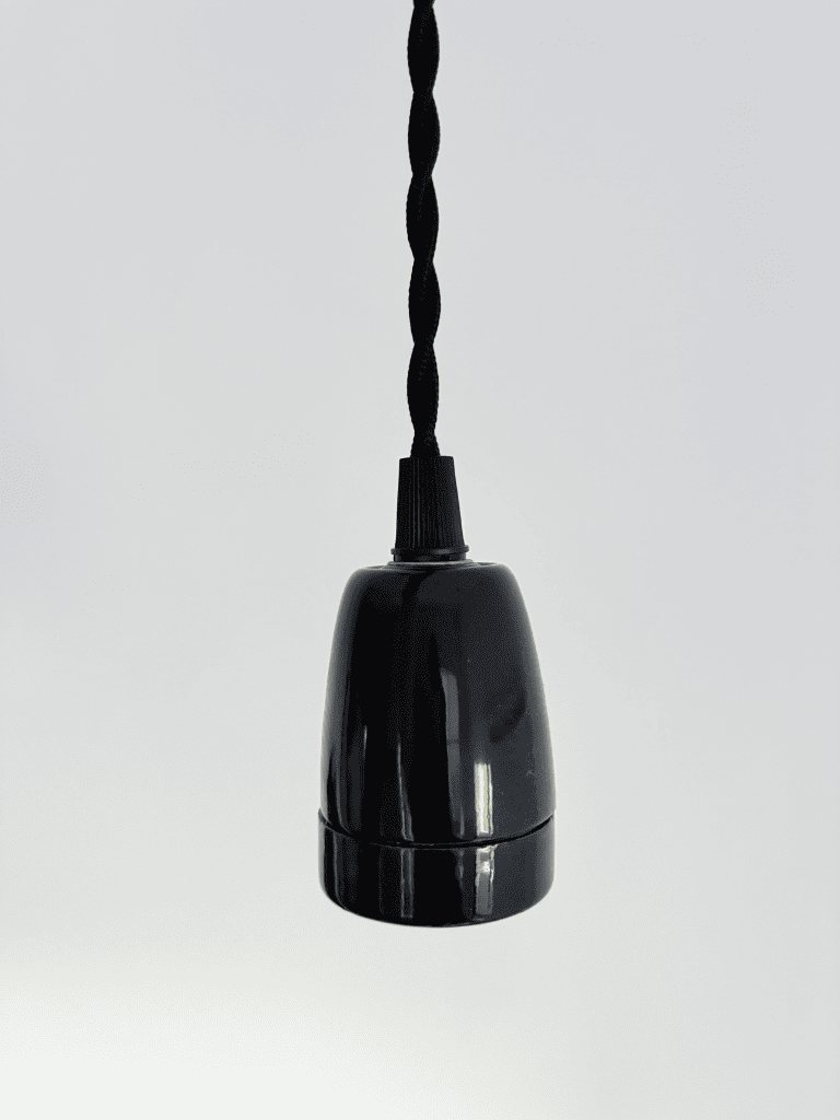 détail d'un luminaire de plafond avec une bouille céramique noire et un câble torsadé vintage au style épuré 
