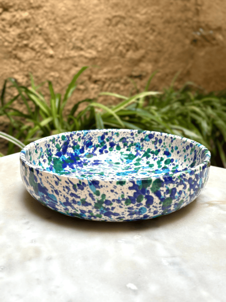 Grand plat à bord tacheté bleu et vert présenté sur une table