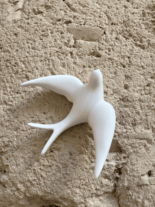 hirondelle blanche suspendue au mur