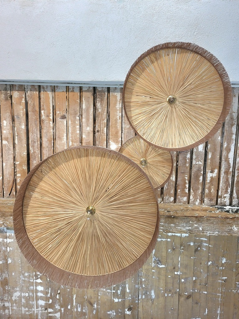 Luminaire en raphia naturel vu du dessous, trois abat-jours de tailles différentes avec franges, fabriqué en France artisanalement.