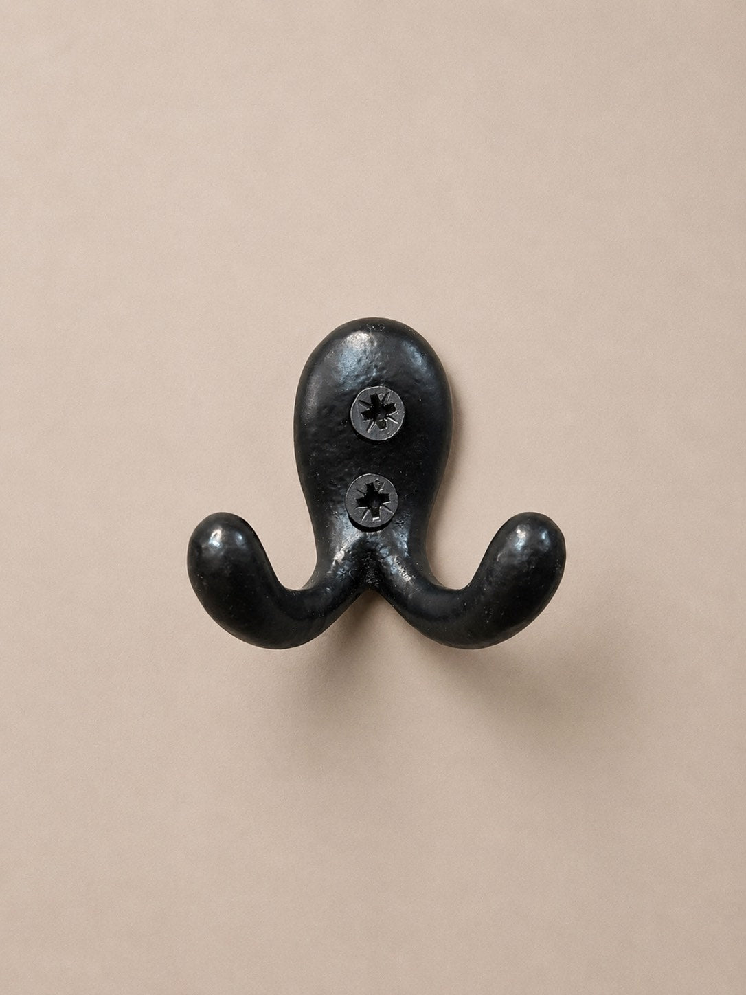 Double mini crochet en métal noir avec une fixation murale qui peut servir tout aussi bien de porte torchons dans une cuisine, de porte vêtement dans une chambre ou de porte serviette dans la salle de bain.
