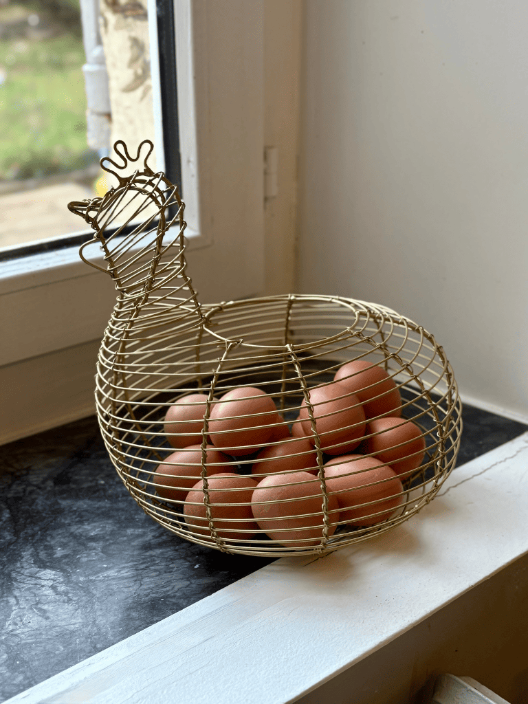 Panier à œufs en fer en forme de poule posé sur une surface