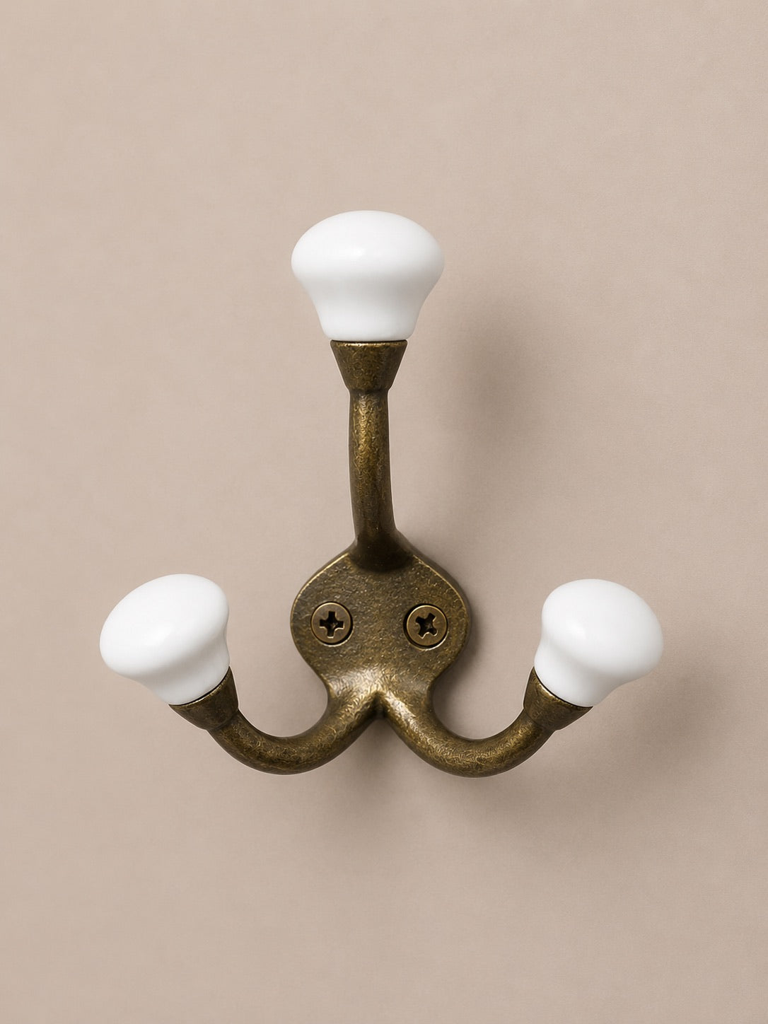 Patère à triple crochet de couleur bronze et embouts en céramique blanc. Peut servir de porte manteaux, porte clés, porte chapeaux à l'entrée ou de porte serviette dans la salle de bain, de porte torchon à la cuisine et de porte vêtement dans une chambre. Pour une décoration campagne chic, rétro.