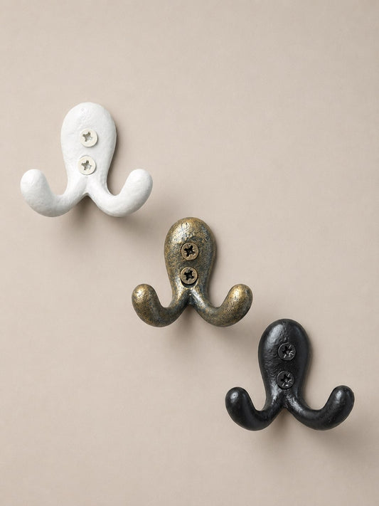 Trois patères en métal, de couleur blanche, doré et noir. Fixation murale, idéal pour faire porte manteaux, porte serviette, porte clés ou encore porte torchon dans la cuisine, salle de bain et entrée.