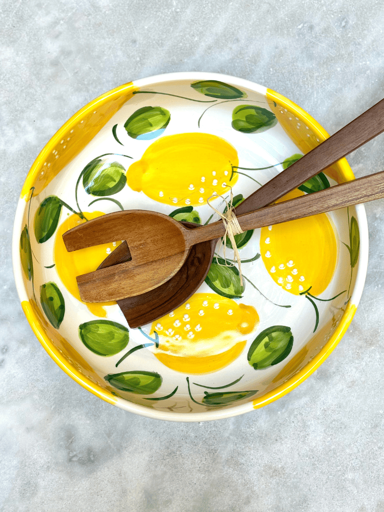 plat rond à bord en céramique décorés de citrons, présentés sur une table de repas, ambiance méditerranéenne