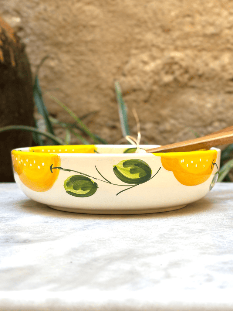 Profil du plat rond en céramique artisanale, bord relevé pour contenir plats chauds ou froids, style méditerranéen. Saladier à motifs citron en terre cuite émaillée. 