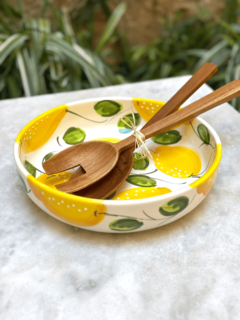 Plat rond à bord en terre vernissée décoré de citrons, posé sur une table de repas, ambiance méditerranéenne et colorée, couvert