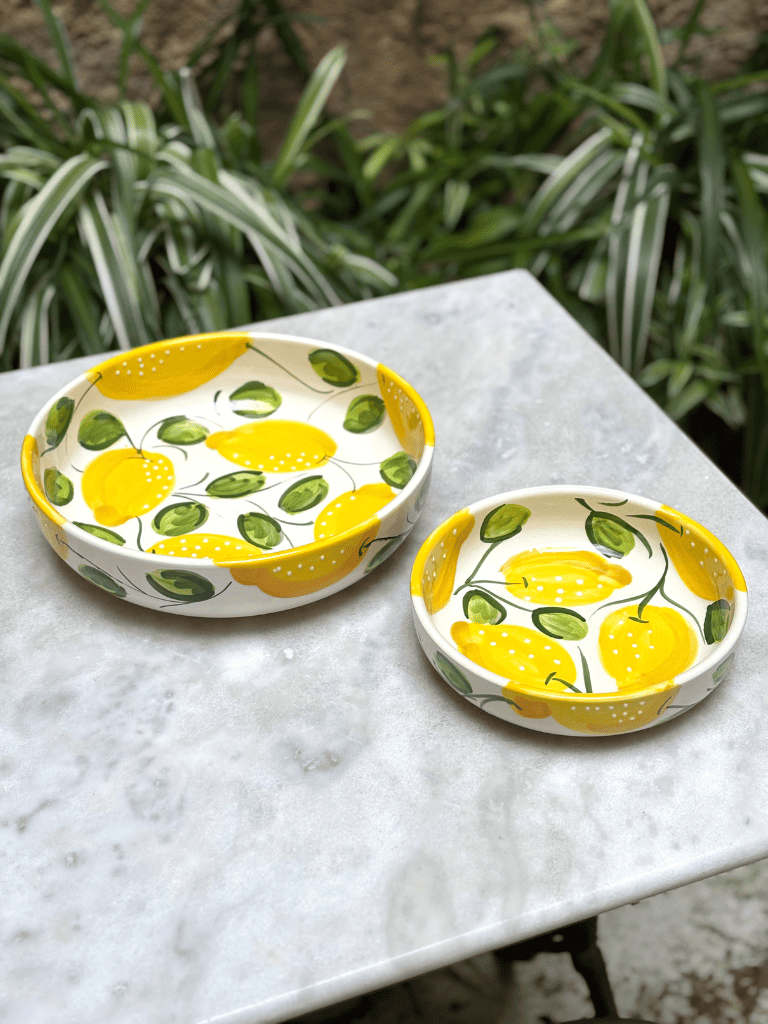 Saladiers, plats ronds à bord artisanaux en terre vernissée, motifs citrons, photo en perspective mettant en valeur le design méditerranéen