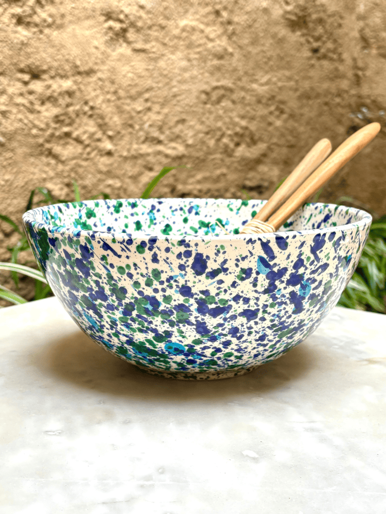 Grand récipient tacheté bleu et vert présenté sur une table de repas