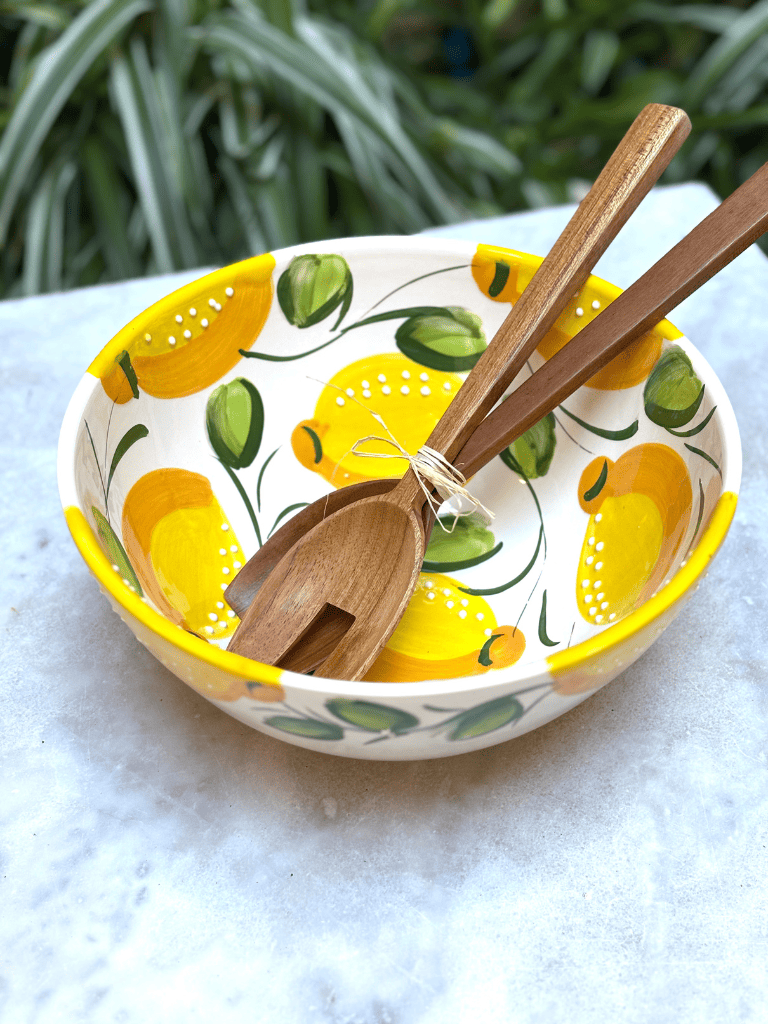 Saladier en terre cuite artisanal espagnol avec décor citron posé sur une table de salle à manger. vaisselle d'été. 