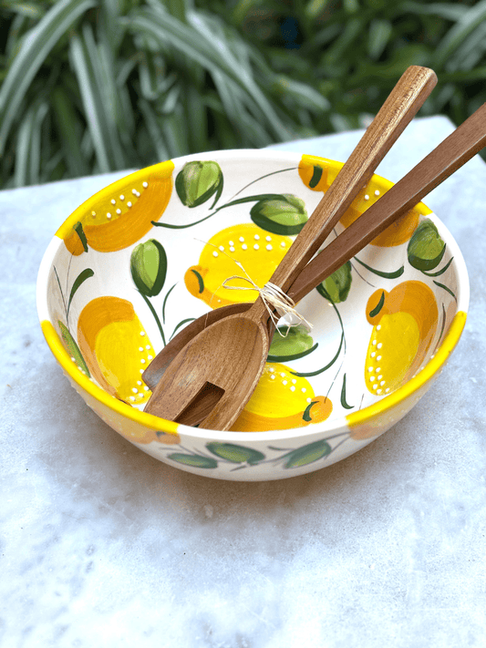 Saladier en terre cuite artisanal espagnol avec décor citron posé sur une table de salle à manger. vaisselle d'été. 