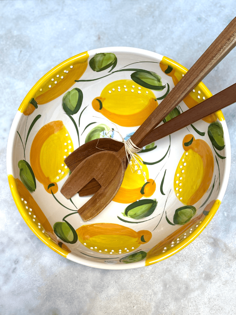 Saladier rond artisanal en céramique, grand bol, motifs de citrons jaunes, vu du dessus. Cuisine d'été. 