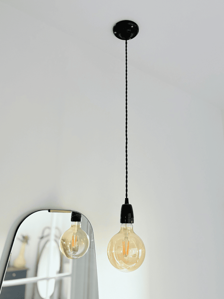 luminaire porcelaine noire dans une salle de bain rosace et douille en porcelaine noire, câble torsadé noir vintage, décoration épurée 
