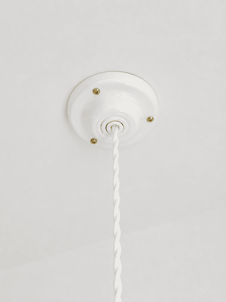 detail de la suspension en porcelaine, plafonnier en céramique blanche et câble torsadé vintage blanc 