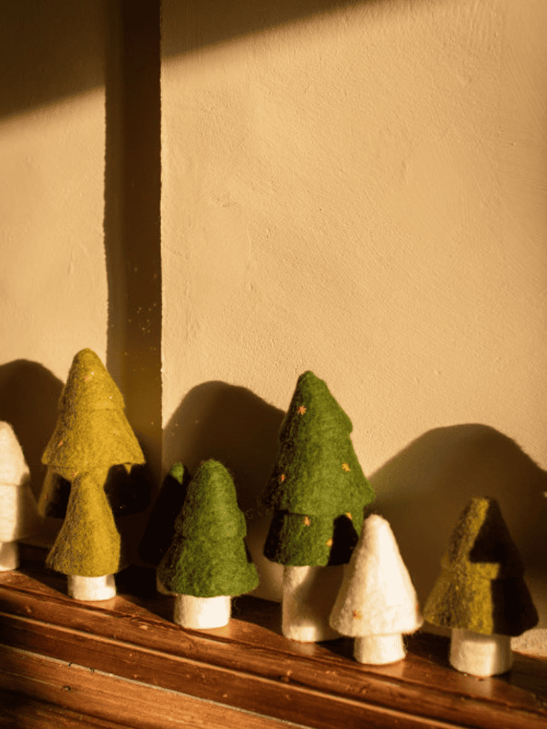Sapin de noël en feutre vert Muskhane posé sur une table en bois, décoration naturelle et artisanale