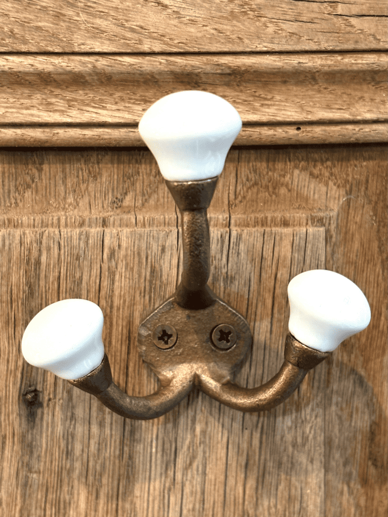 Triple crochet doré en métal et bois dans une entrée