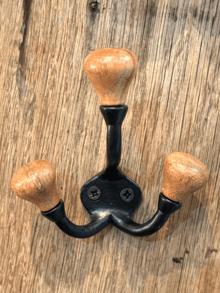 Triple crochet noir et bois fixé au mur