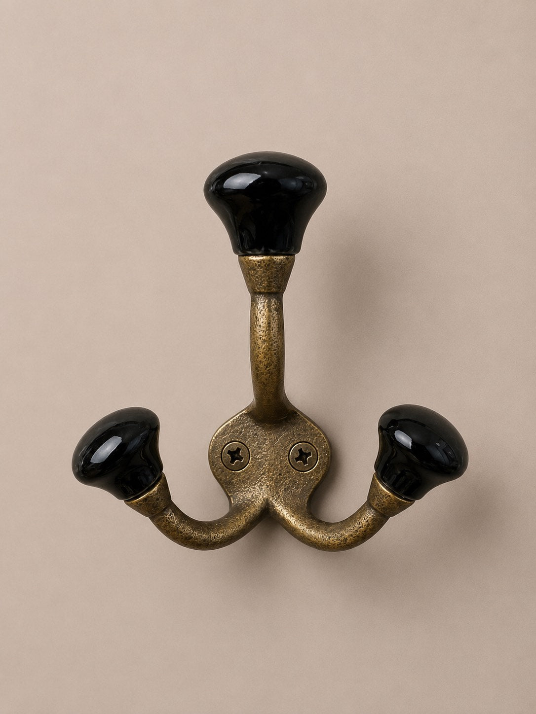 Patère à triple crochet de couleur doré, noir et de matière métallique avec ses embouts en céramique, porcelaine. Fixation murale avec possibilité de le mettre dans une salle de bain pour servir de porte serviette, porte torchon dans une cuisine. Idéal pour une décoration épurée ou vintage.