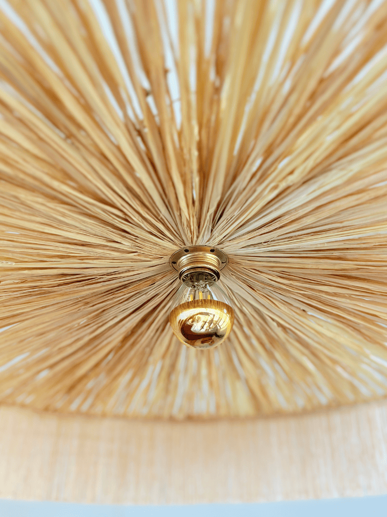 zoom sur l'ampoule de l'abat-jour Parasol et le tressage en fibres naturelles et frange. 